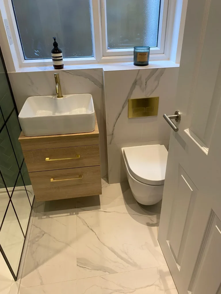 Renovated bathroom with vanity unit, wall-hung toilet and marble-effect tiles – Tenfold Renovation